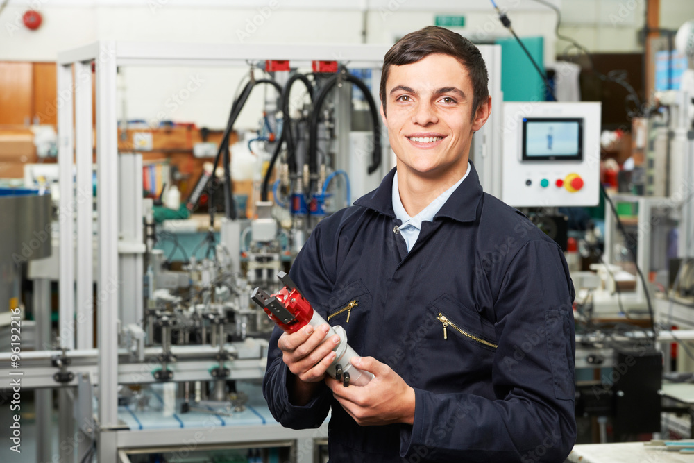 Apprentice Engineer Checking Component In Factory Apprentice Engineer Checking Component In Factory