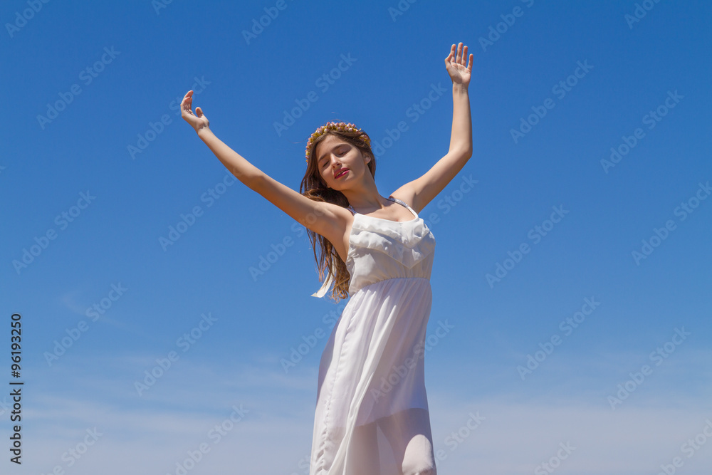 Young brunette in white flimsy dress enjoys the summer sun. Young brunette in white flimsy dress enjoys the summer sun.