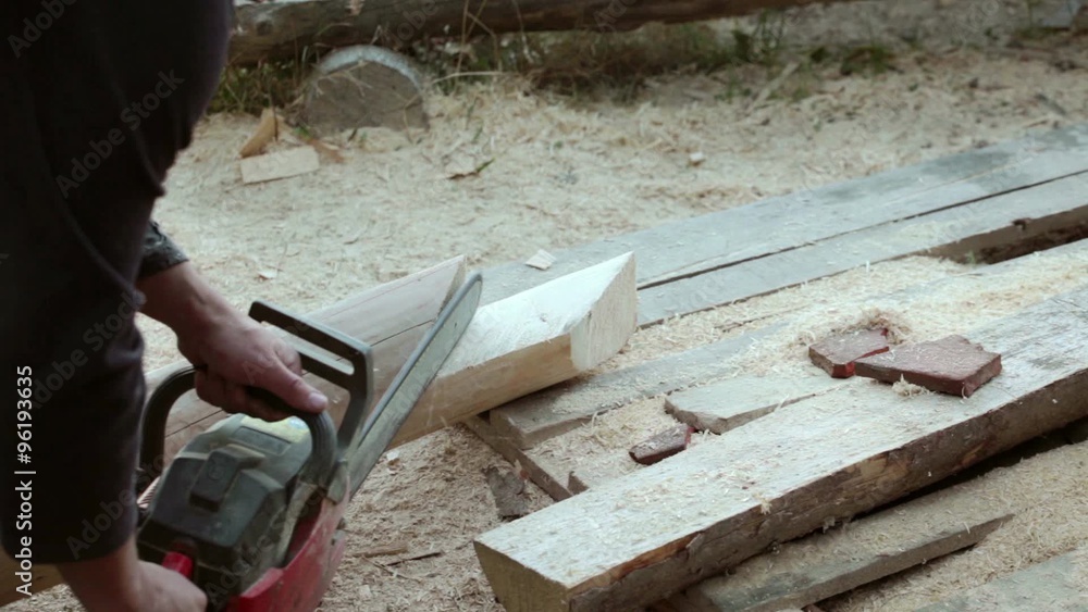 Carpenter carving fir timber using chain saw; close up; Carpenter carving fir timber using chain saw; close up;