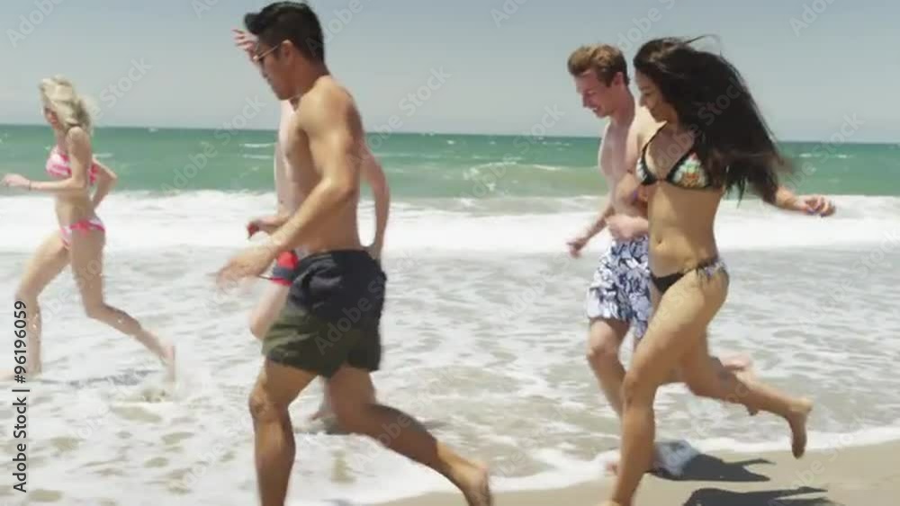 Fresh young adults running along the beach shore Fresh young adults running along the beach shore