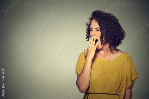 sleepy young woman with wide open mouth yawning eyes closed looking bored
