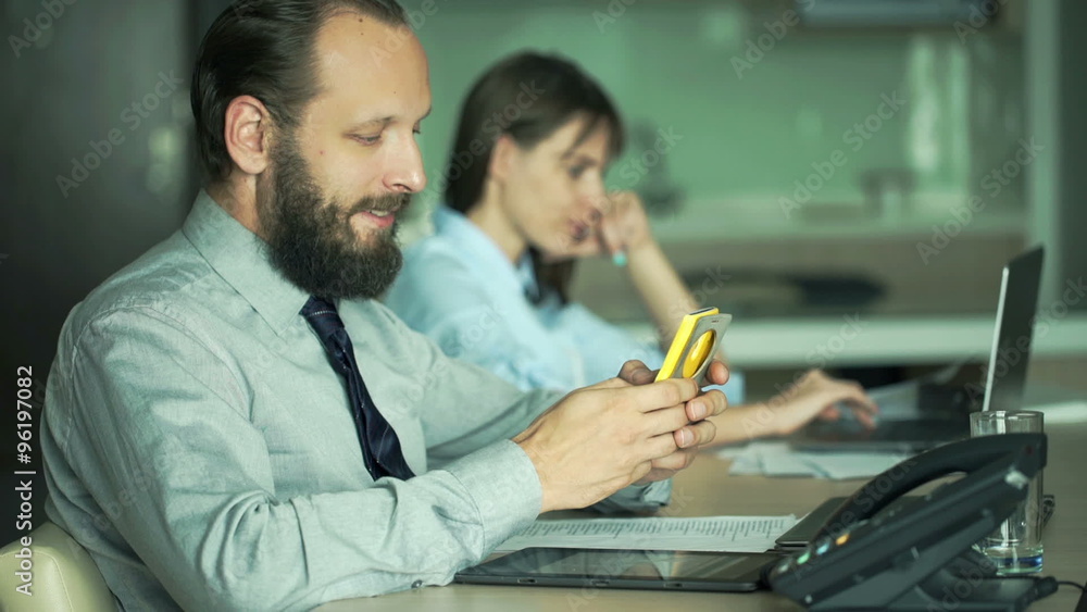 Businesspeople working on laptop and smartphone in office
Businesspeople working on laptop and smartphone in office