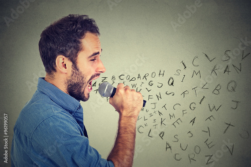 Quadro su tela Young man singing in microphone with alphabet letters coming out of his mouth