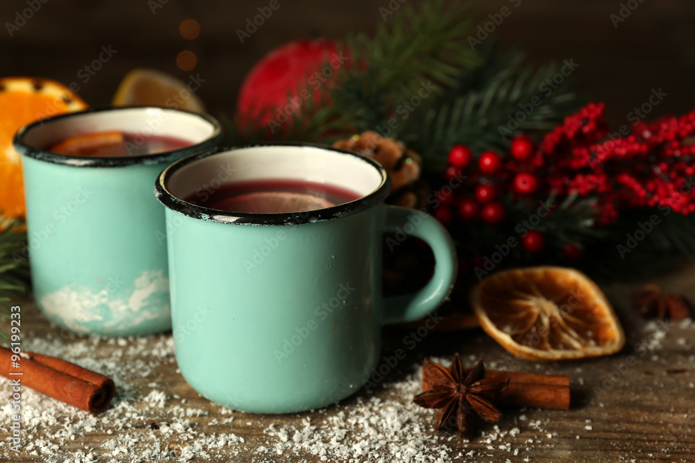 Decorated composition of mulled wine in mugs on wooden table Decorated composition of mulled wine in mugs on wooden table
