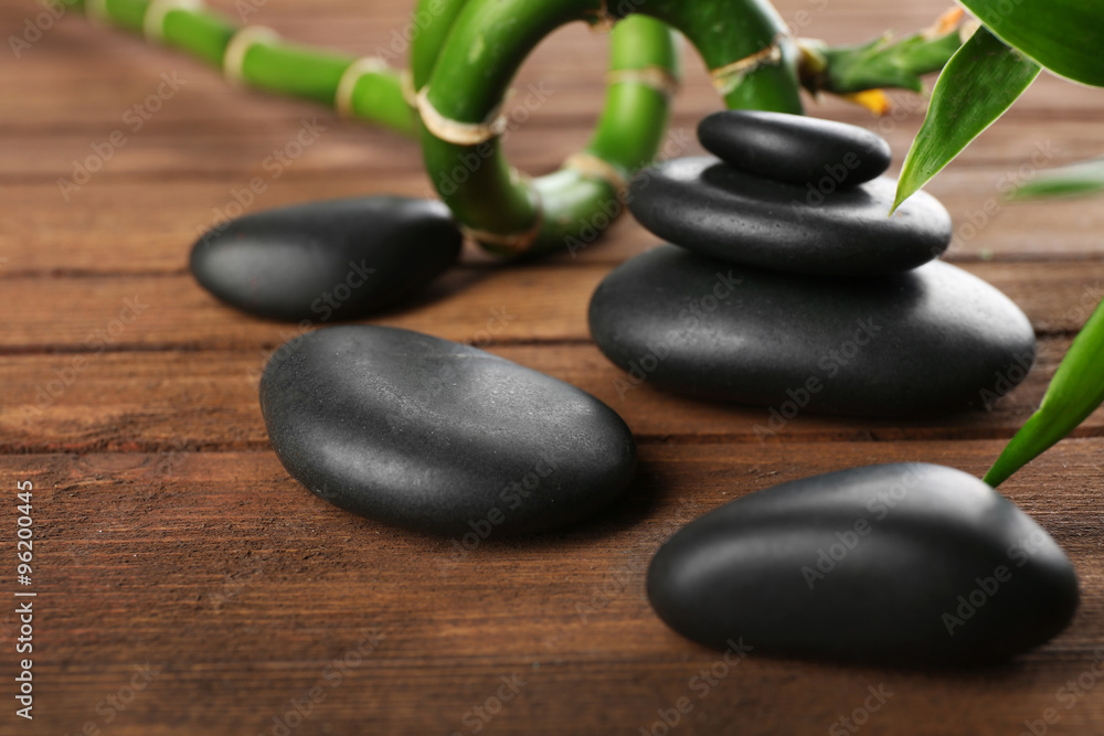 Spa stones and bamboo branch on wooden background Spa stones and bamboo branch on wooden background