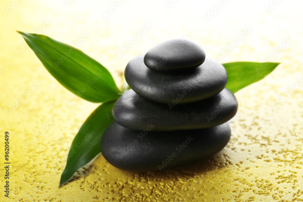 Spa stones and bamboo branch on a light background Spa stones and bamboo branch on a light background