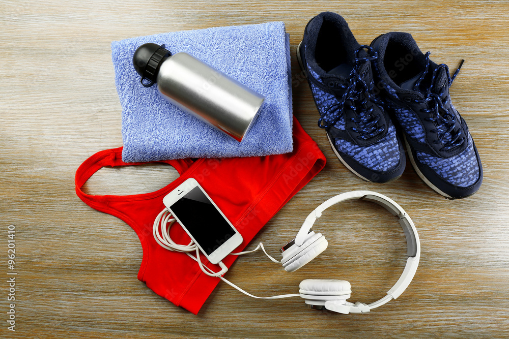 Set for sports and smart phone with headphones on wooden table background Set for sports and smart phone with headphones on wooden table background