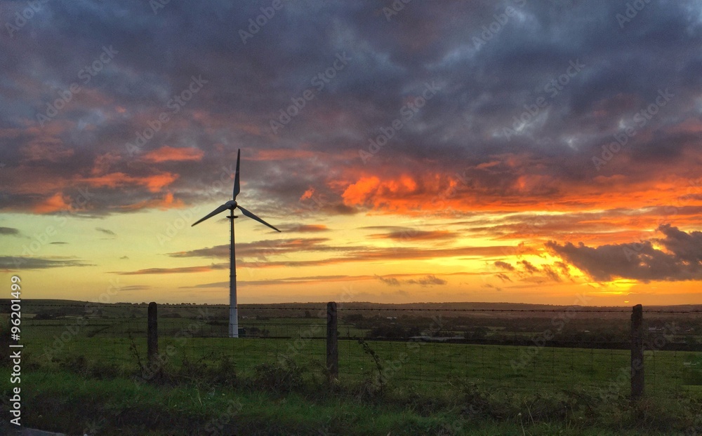 Obraz premium a single wind turbine against a setting sun