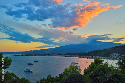 Taormina's Giardini-Naxos bay with the sea and the Etna volcano and Catania in the back in Sicily, Italy at sunset