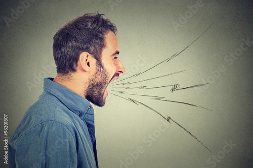 Slika na platnu Side profile portrait of young angry man screaming