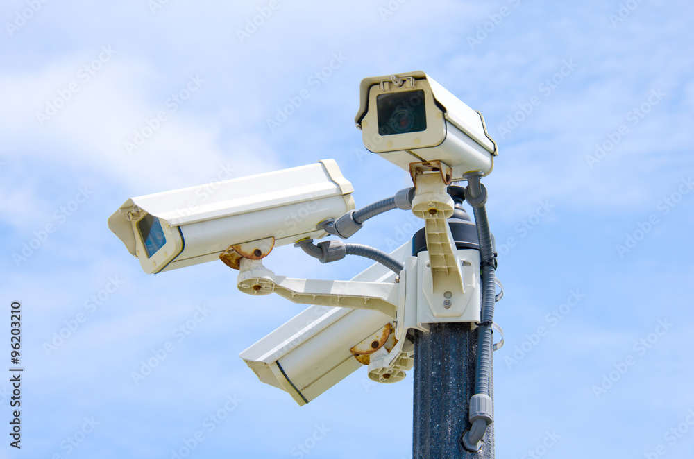 Three outdoor security cameras mounted on a pole