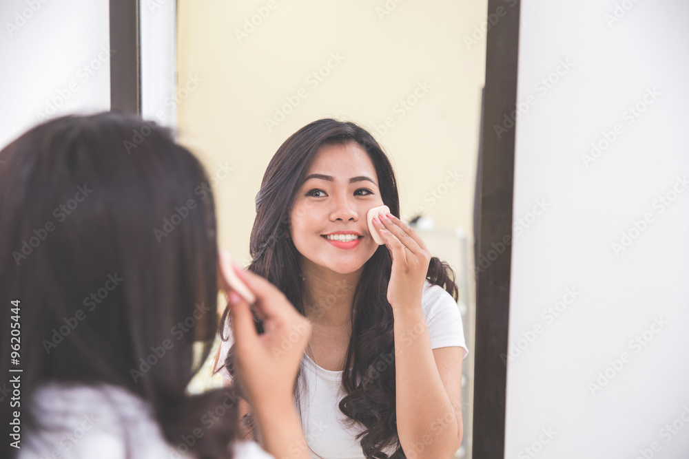 Woman applying make up into her face Woman applying make up into her face
