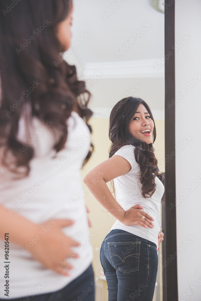 Woman looking her image on the mirror Woman looking her image on the mirror