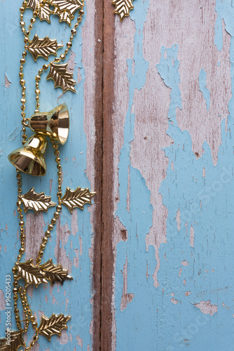 Christmas gold bell chain decorative on grunge blue wooden backg