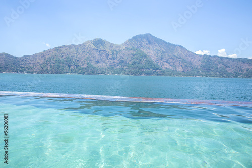 infinity pool with lake and mountain at the background