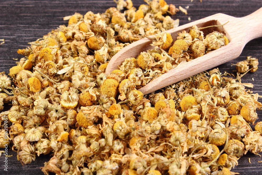 Dried chamomile on wooden table, alternative medicine Dried chamomile on wooden table, alternative medicine