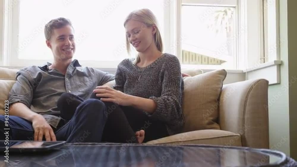 Couple talking on couch in their new apartment Couple talking on couch in their new apartment