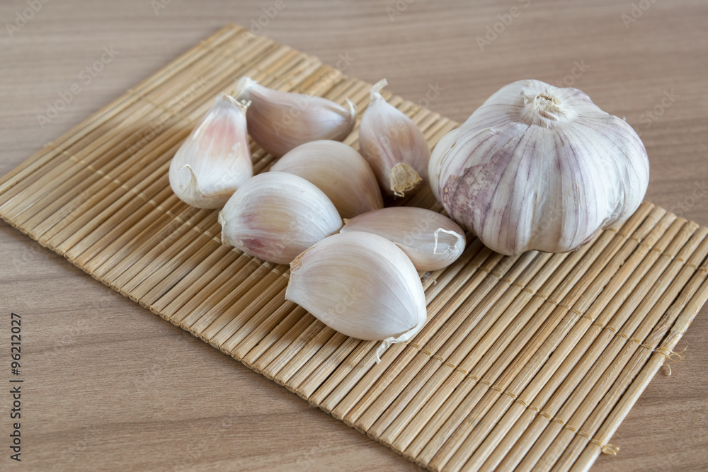 garlic cloves on makisu mat on wood texture garlic cloves on makisu mat on wood texture