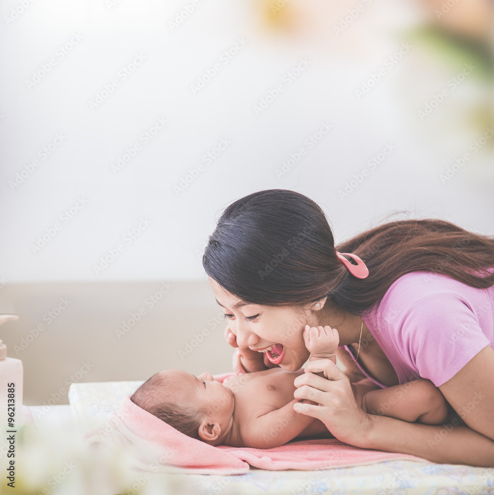 portrait of a mother happily playing with her baby after having portrait of a mother happily playing with her baby after having