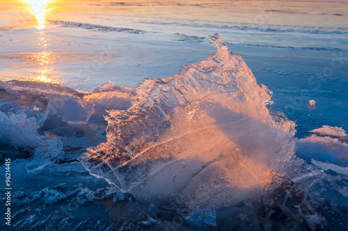 Transparent piece of ice on the frozen lake at sunset © Joe-L