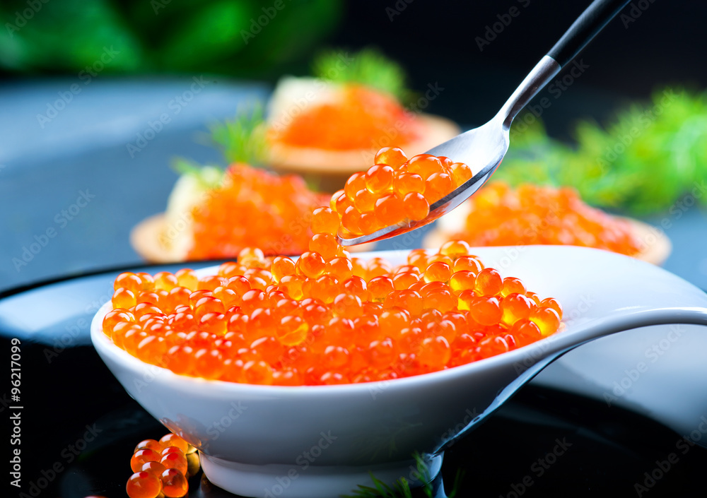 Caviar. Red caviar in spoon on a black background. Gourmet food closeup Caviar. Red caviar in spoon on a black background. Gourmet food closeup