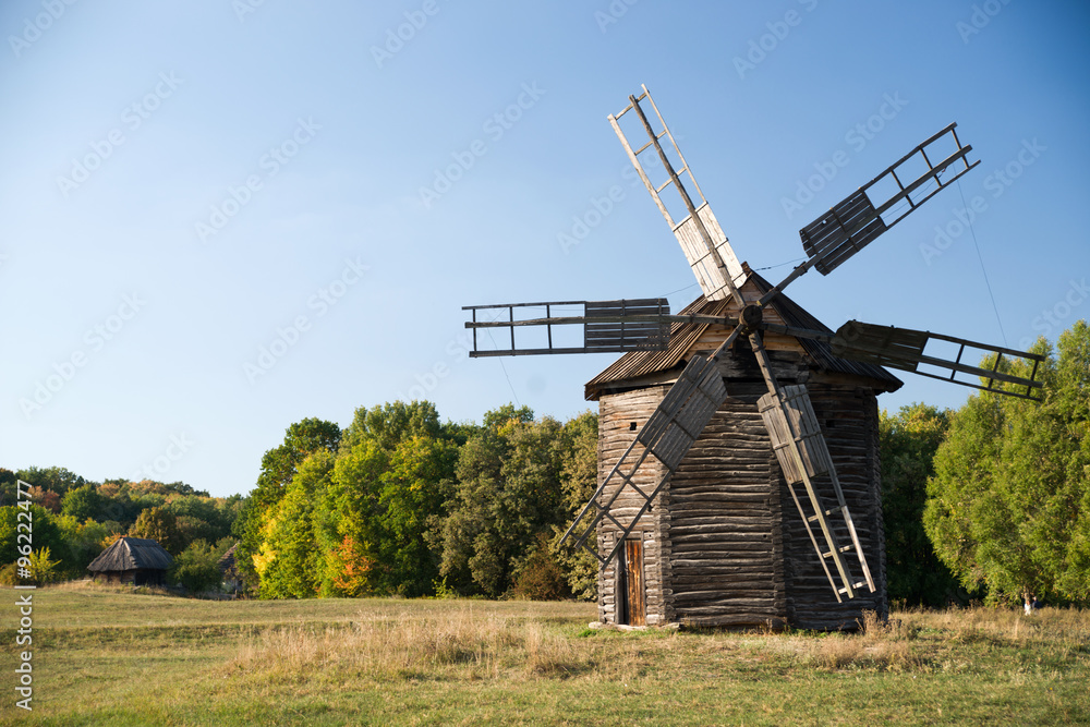 Windmill standing on the edge of the autumn forest