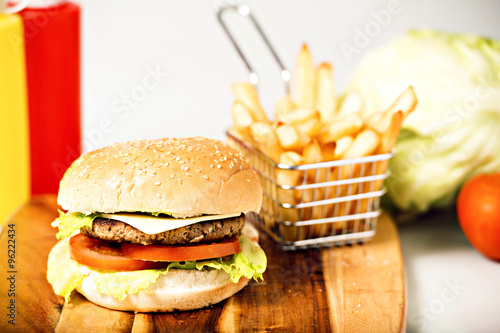 Hamburger with cheese, potato chips and ingredients on a white background