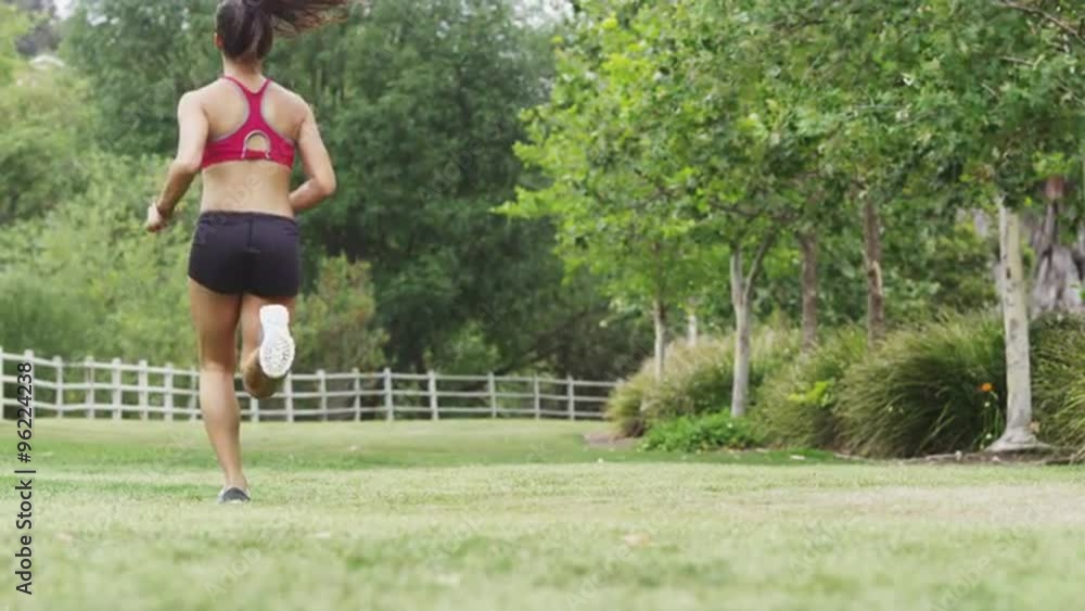 Healthy young Asian woman running slow motion at the park