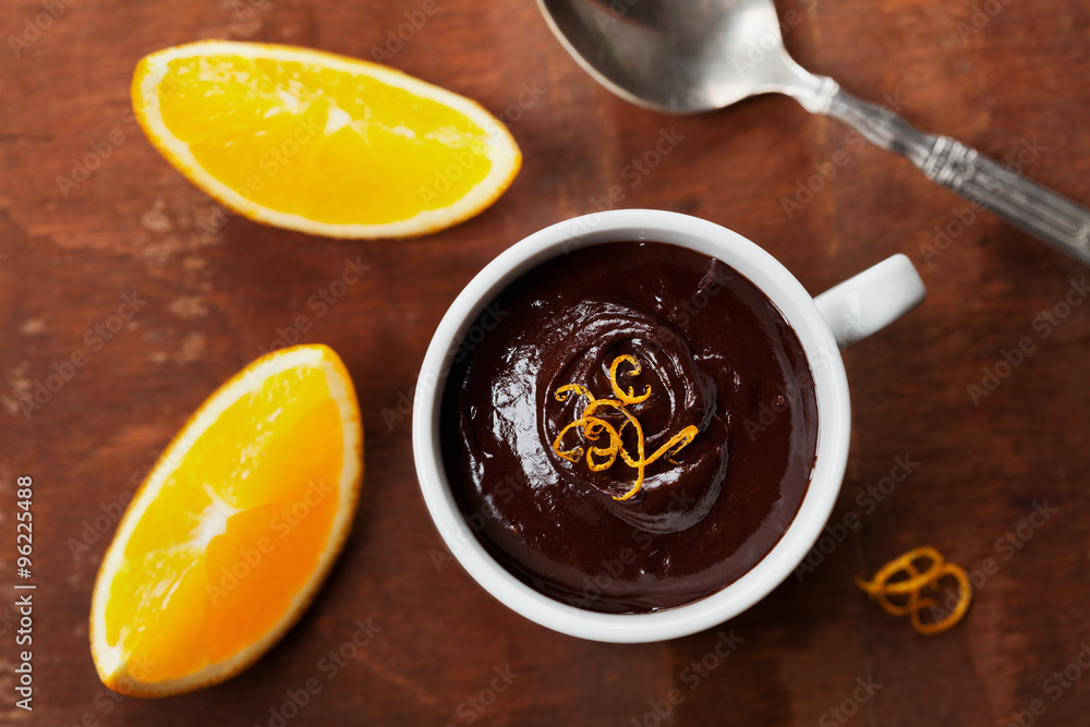 Tasty dessert from dark chocolate mousse with orange slice decorated citrus peel on rustic table, top view Tasty dessert from dark chocolate mousse with orange slice decorated citrus peel on rustic table, top view