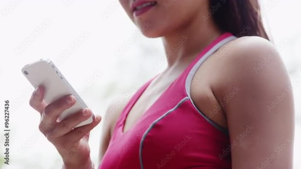 Young fit Asian woman resting texting at the park Young fit Asian woman resting texting at the park