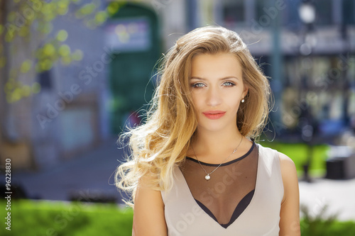 Portrait close up of young beautiful blonde woman, on background