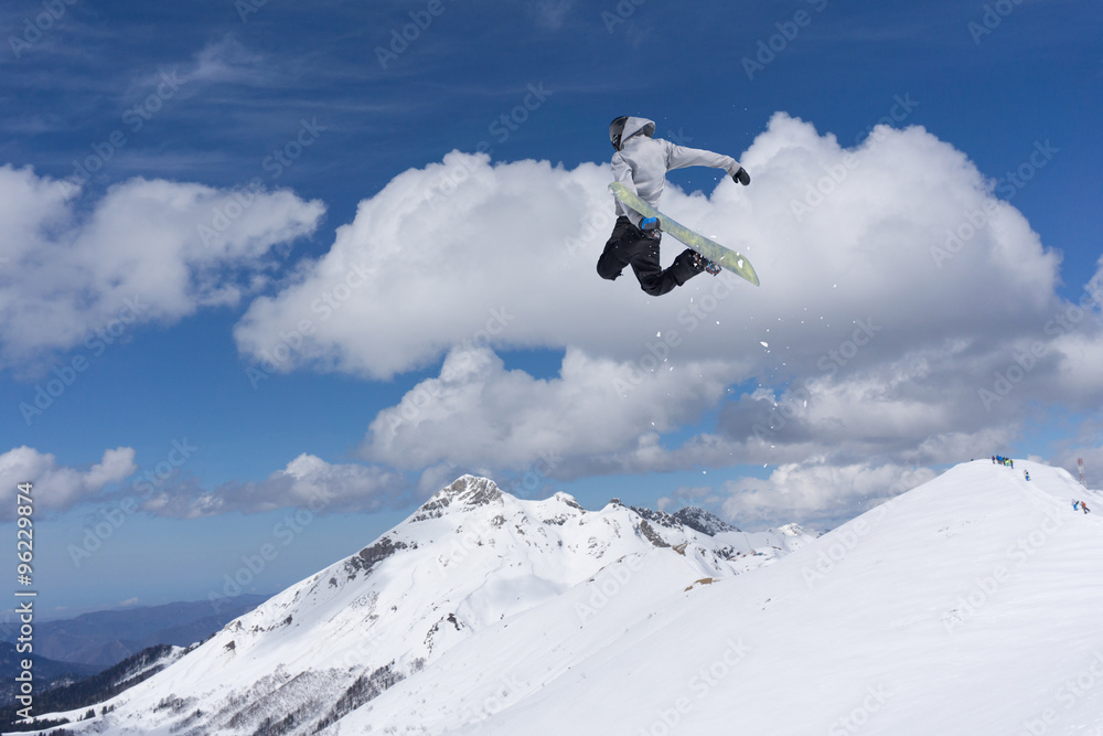 Flying snowboarder on mountains Flying snowboarder on mountains
