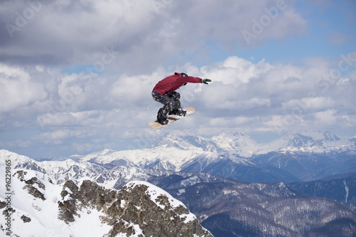 Flying snowboarder on mountains