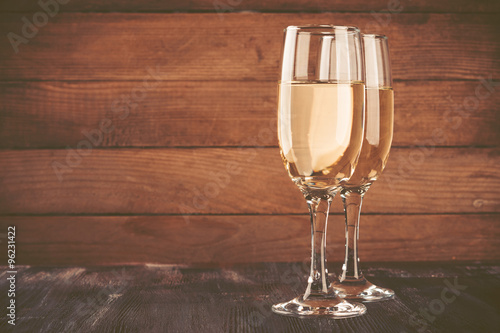 Glasses of champagne and gift on white background. Toned image. Vintage style.