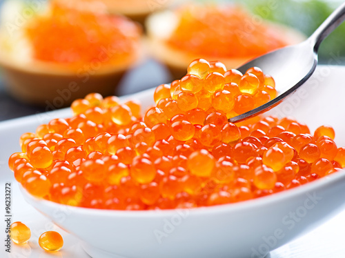 Caviar. Red caviar in spoon on a white background. Gourmet food closeup