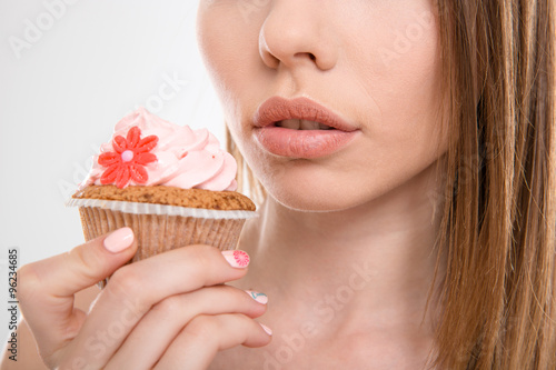 Pretty sensual woman trying to eat a cupcake