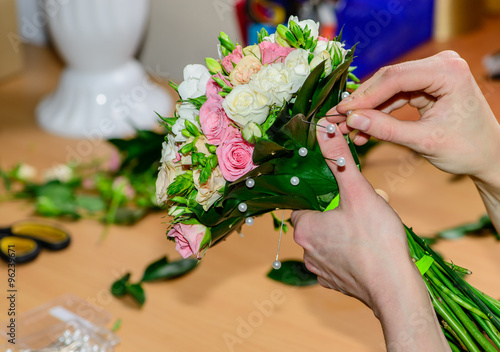 closeup florist making a bouquet of flowers. Shallow depth of fi