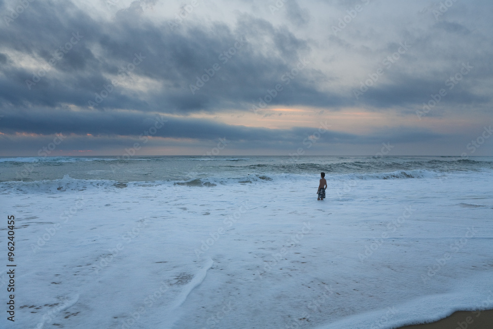 Sunset Swimming. A Lone swimmer heads off into the great big space of nature where sea and sky join. The sun is setting and a storm is brewing. Sunset Swimming. A Lone swimmer heads off into the great big space of nature where sea and sky join. The sun is setting and a storm is brewing.