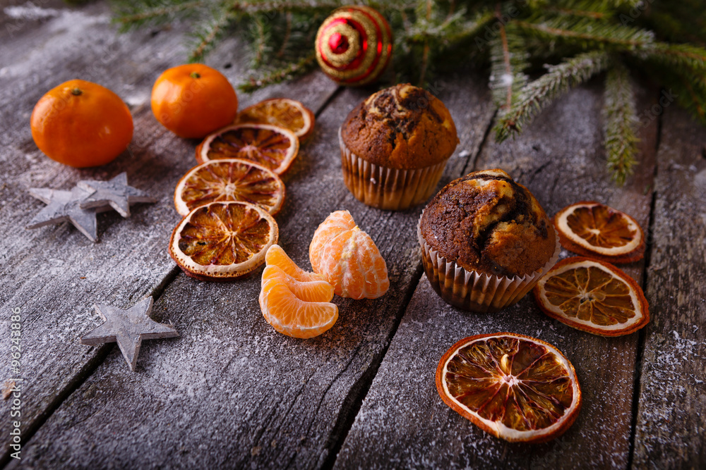 Xmas or new year composition with holiday decoration - Homemade christmas cupcakes, sliced dried oranges on wooden background with spruce twigs and christmas toy. Christmas card. Space for text Xmas or new year composition with holiday decoration - Homemade christmas cupcakes, sliced dried oranges on wooden background with spruce twigs and christmas toy. Christmas card. Space for text