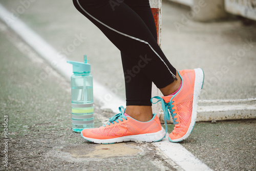 Urban fitness lifestyle and sportswear concept. Sport running shoes and bottle of water close up.