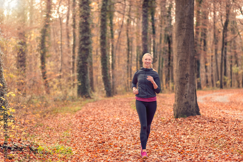 Hübsche fitte blonde Frau joggt im Wald