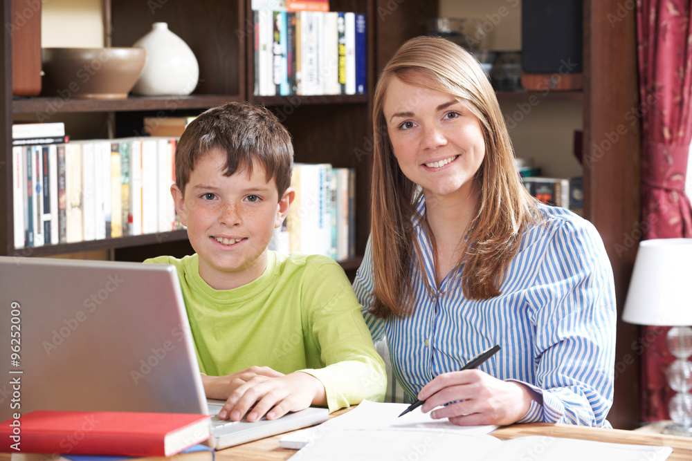 Female Tutor Helping Boy With Home Studies Female Tutor Helping Boy With Home Studies