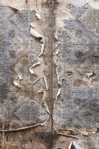 Aged room wall background with torn vintage wallpaper.