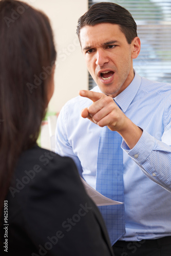 Aggressive Businessman Shouting At Female Colleague photo