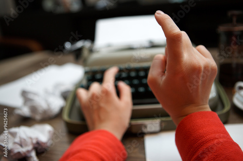 woman typing on old typewriter