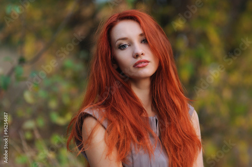 Fototapeta Outdoors portrait of beautiful young woman with red hair