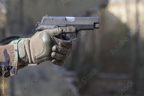 gun and camouflage gloves
