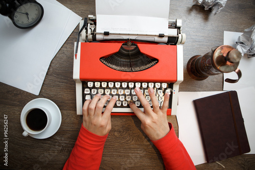 Vintage red typewriter with blank paper photo