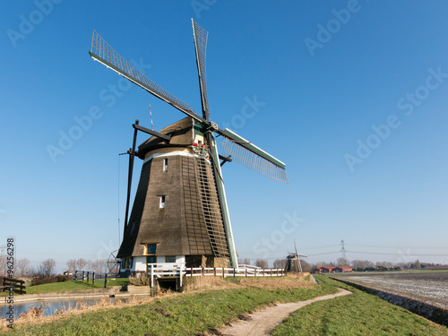 Photo Two windmills in a row in polder near Zevenhuizen in the province of South Holla