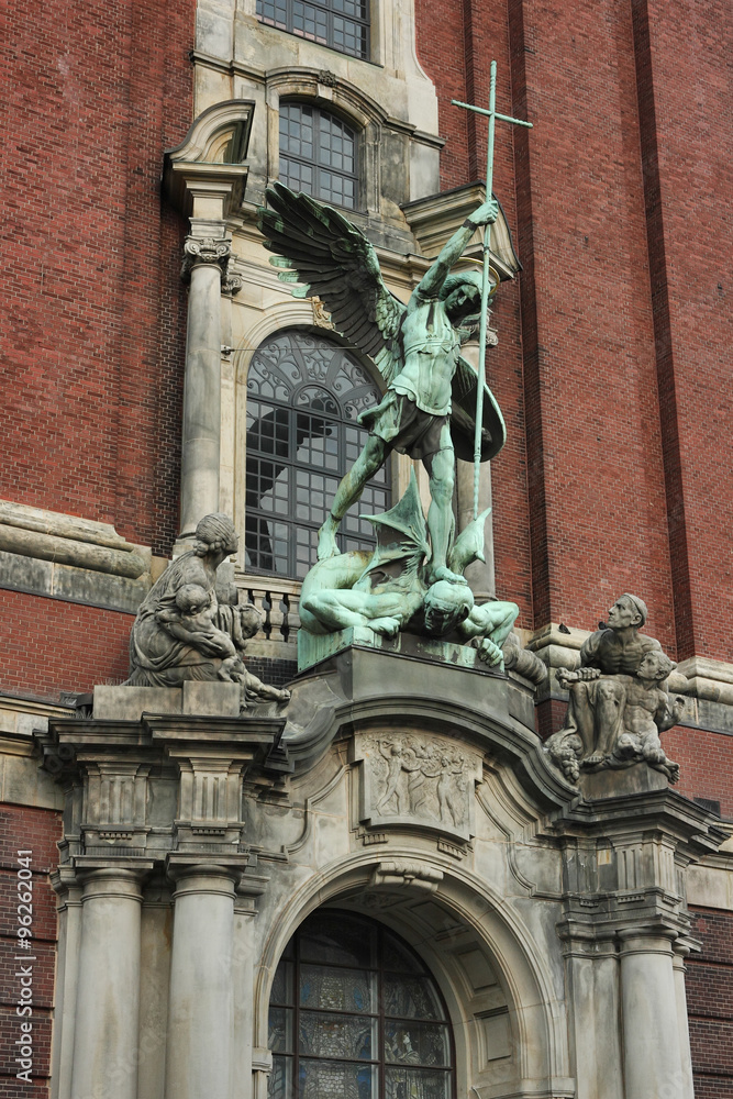 A religious sculptural composition.
Bronze statue of the Archangel Michael is located above the main portal of the St. Michael's Church in Hamburg.